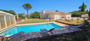 a swimming pool with two chairs and a house at La parenthèse Provençale-Maison à Grillon avec wifi in Grillon