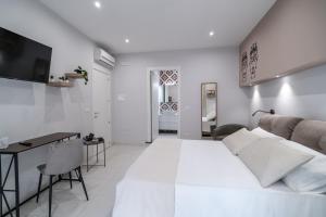 a white living room with a bed and a desk at La Casa di Peppolo in Randazzo