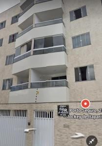 a tall building with a sign in front of it at Apartamento 1 km da praia com ar e garagem in Vila Velha