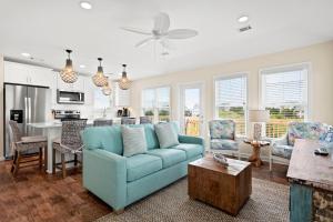 a living room with a blue couch and a kitchen at Cloudless Day in Nags Head