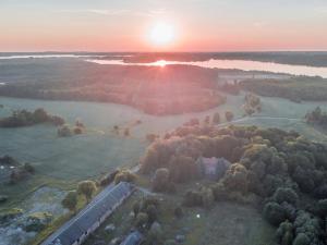 an aerial view of a field with the sunset in the background at Gunram Mazury in Okowizna