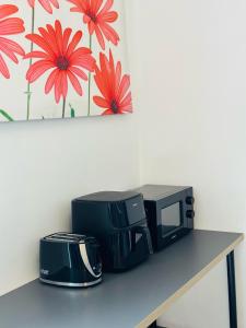 a microwave sitting on a table next to a toaster at Apex Rooms Manchester in Manchester
