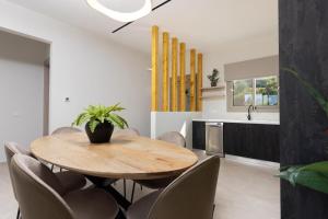 a dining room with a wooden table and chairs at Villa Ismini Periyali in Vasilikos