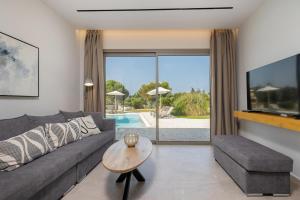 un soggiorno con un divano e un tavolo di Villa Ismini Periyali a Vasilikós