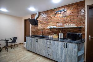 a kitchen with a brick wall and a counter at Green Garden Guesthouse in Tbilisi City
