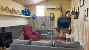 a living room with a couch and a tv at Imperio de Memorias - Casa de Campo in Vale Bordalo