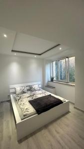 a white bedroom with a large bed in it at Apartament Nad Potokiem in Mieroszów
