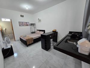 a bathroom with a bed and a sink in a room at Flat completo a 21 minutos da BR-153 in Aparecida de Goiania