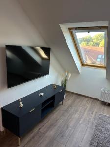 a living room with a large flat screen tv on a wall at Flex Apartments Blue in Mosonmagyaróvár