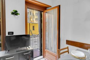 Una sala de estar con televisión y una gran ventana. en flat pet friendly free wifi inalpi arena olimpico metro, en Turín