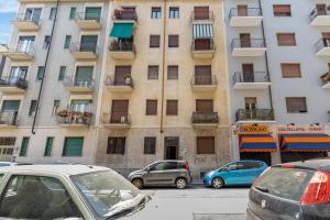 Un edificio alto con coches aparcados delante. en flat pet friendly free wifi inalpi arena olimpico metro, en Turín