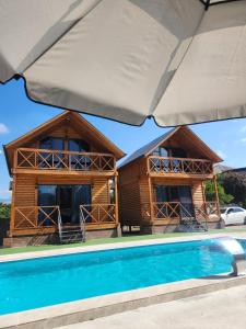 a resort with a swimming pool in front of a house at Seaside Cottages, BEDO HOUSE in Batumi