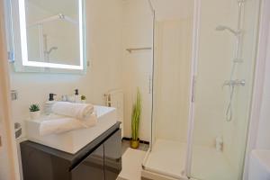 Un baño blanco con ducha y lavabo. en La Terrasse Douillette, en Saint-Étienne 10 fotos más