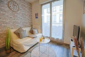 una sala de estar con un sofá y una mesa en La Terrasse Douillette, en Saint-Étienne
