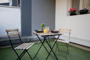 a table with two chairs and a table with drinks on it at La Terrasse Douillette - Pl Jean Jaurès - Terrasse in Saint-Étienne