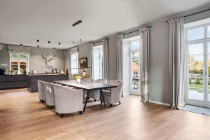 eine Küche und ein Esszimmer mit Tisch und Stühlen in der Unterkunft GUT KLETKAMP "Försterei" - Freistehendes Backsteinhaus mit 4 Schlafzimmern ruhig am Waldrand gelegen I Kamin I Garten & Terrasse I 15 Min zur Ostsee I 3 Bäder I Küche I Parkplatz I WLAN in Kletkamp