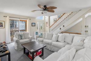a living room with white furniture and a staircase at Corolla & Lime in Corolla