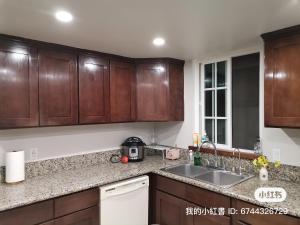 a kitchen with wooden cabinets and a sink at 1 bedroom in a quiet neighborhood near the main street - Room B in Rowland Heights +8 photos