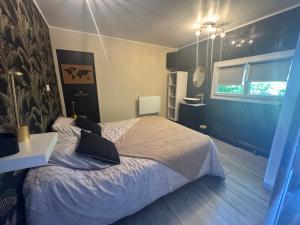 a bedroom with a bed and a table and a window at Studio proche aéroport de Nantes in Saint-Aignan-Grand-Lieu