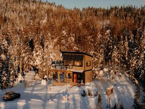 a house in the snow in front of a forest at Le Hélios - MicroChalet au Maelstrom in Lac-Beauport