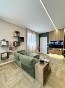 a living room with a green couch and a table at Valcamonica Apartments - Mountain in Boario Terme