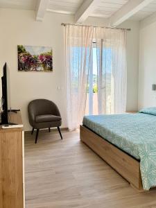 a bedroom with a bed and a chair and a window at Vera Hotel in Porto San Giorgio