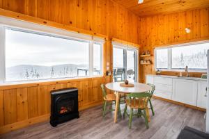 a kitchen and dining room with a table and a stove at Le Hélios - MicroChalet au Maelstrom in Lac-Beauport