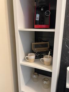 a kitchen pantry with two cups and a toaster at Studio proche aéroport de Nantes in Saint-Aignan-Grand-Lieu