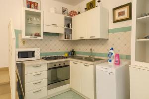 a kitchen with white cabinets and a sink and a microwave at Dream View in Positano in Positano +9 photos
