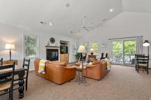 a living room with two couches and a table at Country Roads in Corolla