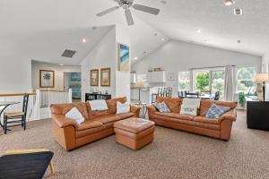 a living room with two couches and a kitchen at Country Roads in Corolla