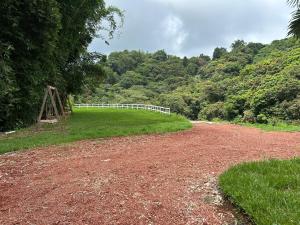 HueytamalcoFinca Pata Jaguar的一条有白色围栏的土路