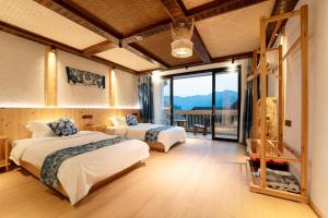 雷山县Xijiang Longtang Liyuan Mountain Resort B&B的一间有两张床和一扇大窗户的卧室
