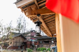 雷山县Xijiang Longtang Liyuan Mountain Resort B&B的窗户上方遮阳篷上悬挂的灯 更多1张照片