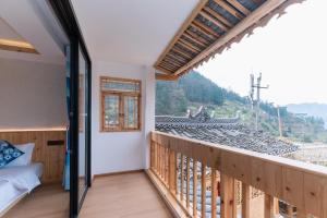 雷山县Xijiang Longtang Liyuan Mountain Resort B&B的客房设有一个享有火车美景的阳台。