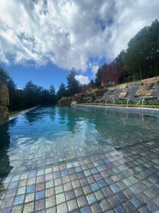 a swimming pool with blue water in the middle at La Torre d' Espinalbet in Castellar del Riu