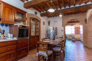 a kitchen with a wooden table and a dining room at Podere le Fonti in Poggibonsi
