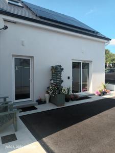 a white building with plants on the side of it at Taobh na Farraige in Belmullet