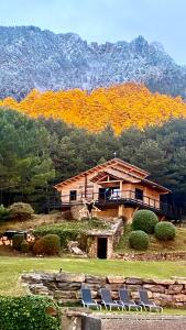 a house on a hill with chairs in front of it at La Torre d' Espinalbet in Castellar del Riu