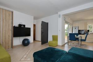 ペトルチャネにあるMare 9 Cozy Two Bedroom Apartment with Gardenのソファとテレビのあるリビングルーム