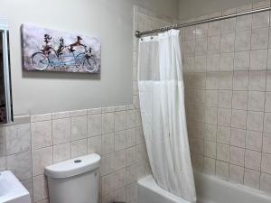 Haven 2 Bedroom by EWR airport في نيوآرك: حمام به لوحة لشخصين على دراجة +10 صور