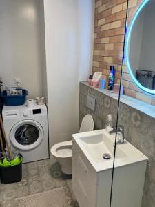 ein Badezimmer mit Waschbecken und Waschmaschine in der Unterkunft Apartament MioMare, Basen, Parking in Kołobrzeg