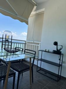 a table and chairs on a balcony with a view of the ocean at Eleny Apartments in Perea