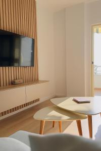 a living room with a table and a tv at Manta Apartment Albania in Golem