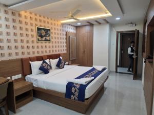 a bedroom with a bed and a person standing in a doorway at Hotel Deccan Park in Haidar Sāhibgūda