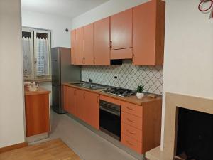 a kitchen with wooden cabinets and a stove top oven at Appartamento a due passi dal centro in Racale