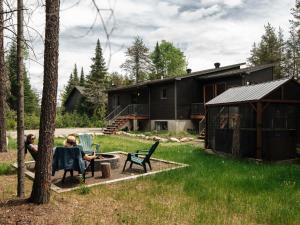 a couple sitting in a yard in front of a house at Chalet Ankoay - Relaxation Nature & Private Spa in Saint Come