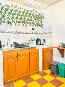 a kitchen with orange cabinets and a checkered floor at Apto cerca al parque de Jardín in Jardin +13 photos