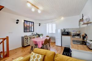 a living room with a table and a kitchen at Maison WonderLodge - Déco Disney - Jeux pour tous - Proche Disney et Paris in Bussy-Saint-Georges +18 photos