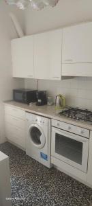 a kitchen with a stove and a washing machine at Casa delle fiabe in Sestri Levante